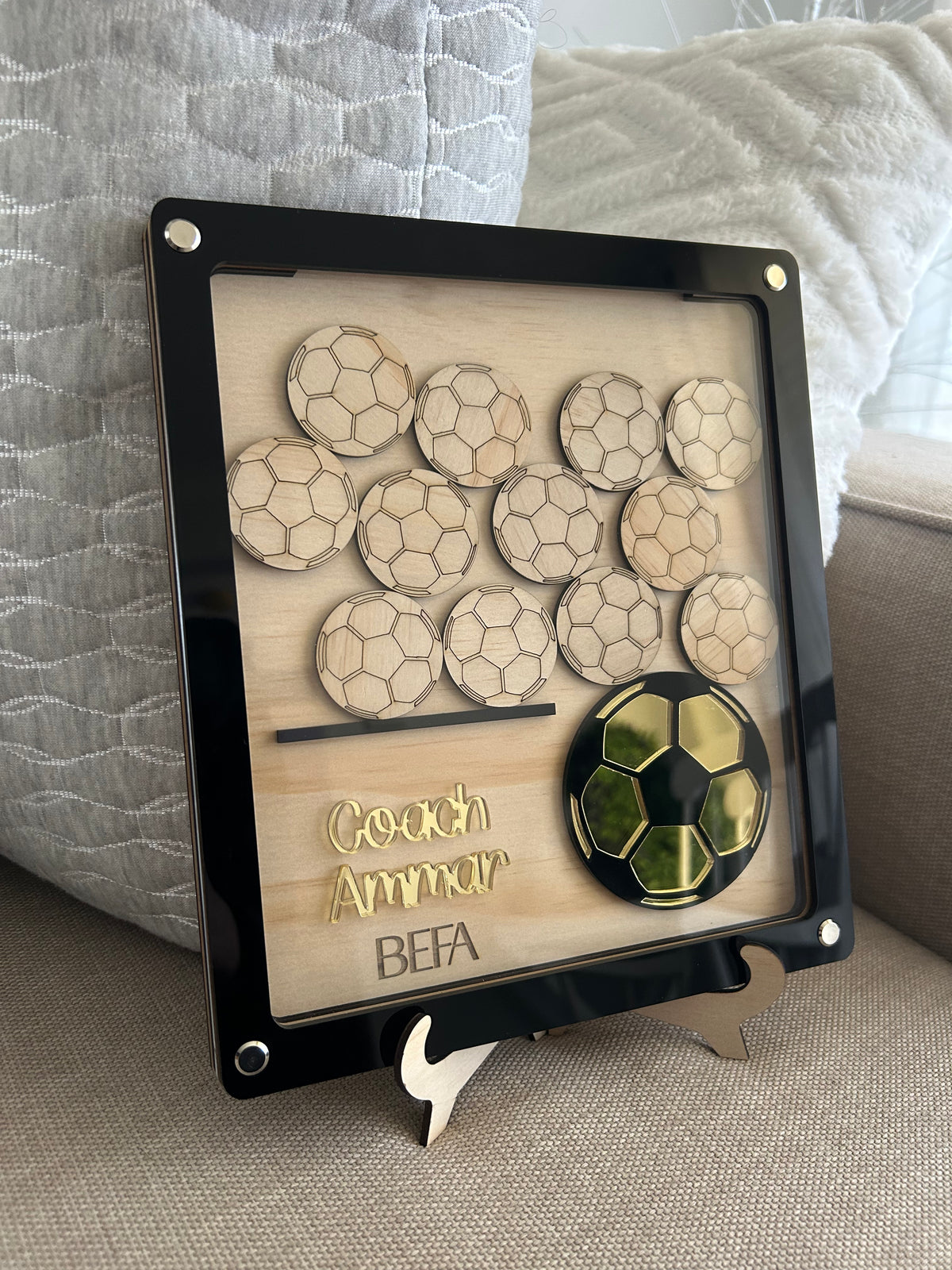 Personalised sporting coach drop box in layered wood and acrylic with twelve wooden ball pieces for the team to sign