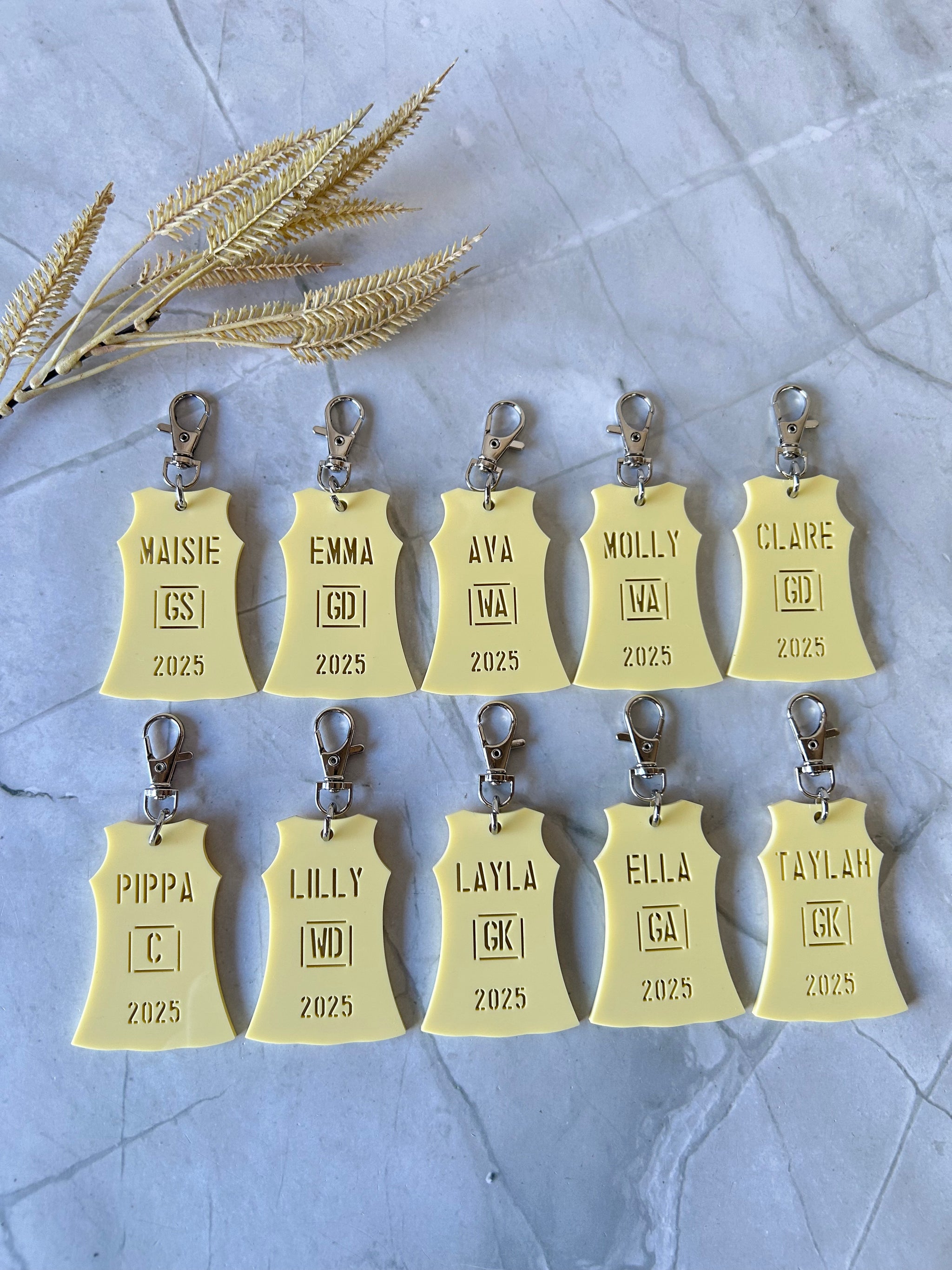 Personalised netball dress bag tag with player name and position in team colours, engraved acrylic